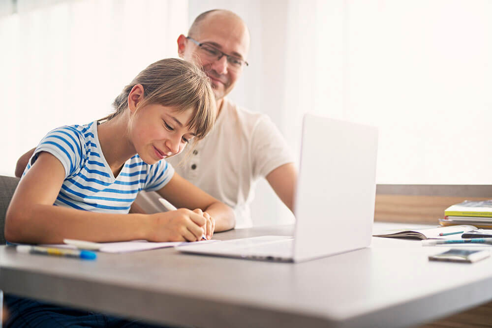 Un père aide sa fille avec ses devoirs.
